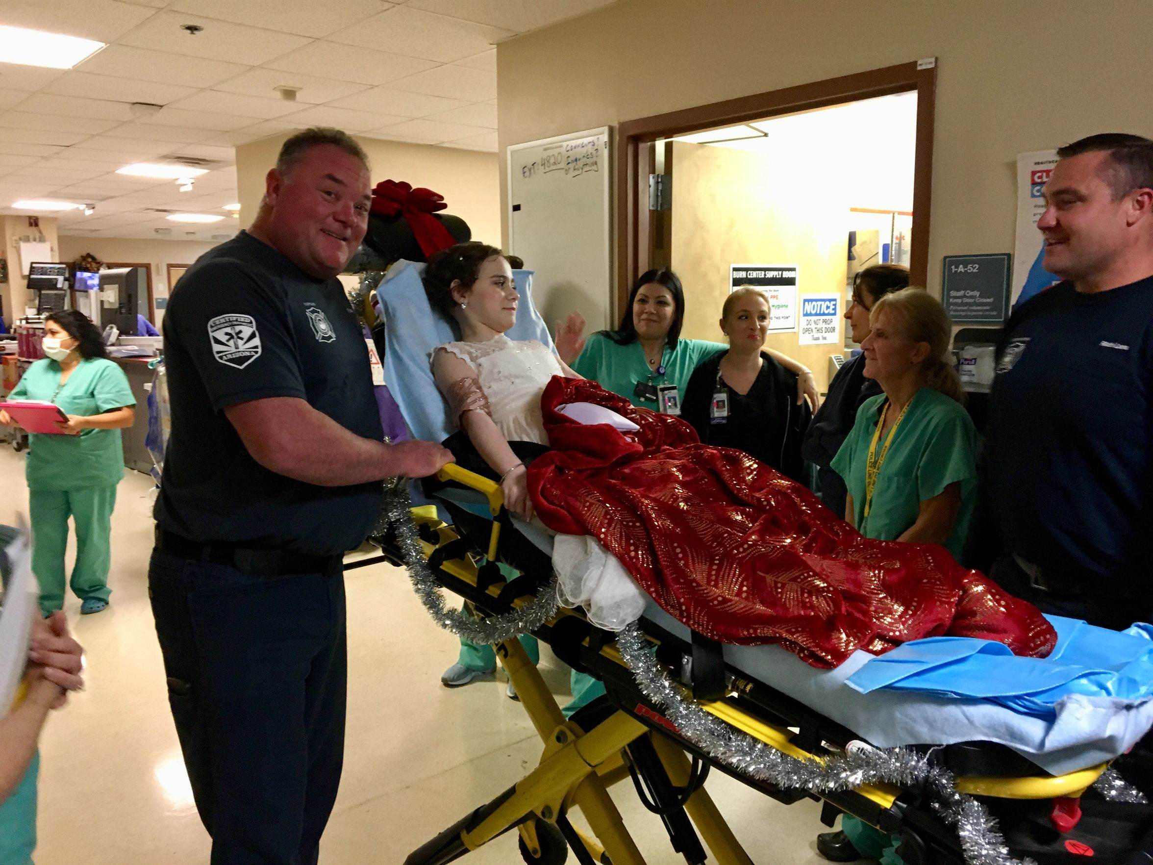 Firefighters Kevin Duzy and Rich Lara escorte Isabella McCune to the Arizona Burn Foundation's gala on Dec. 8, 2018. It was the first time Isabella had left the hospital in 268 days.