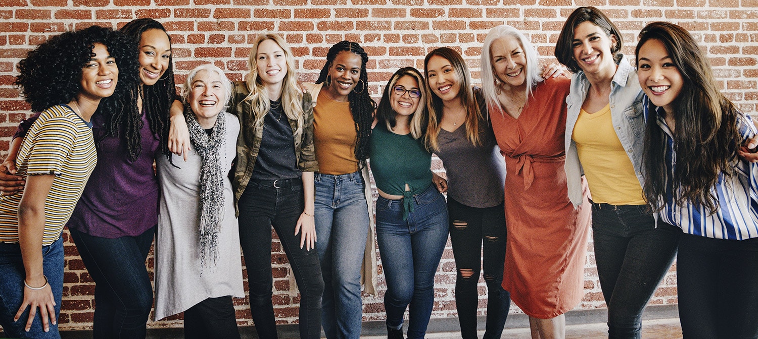 happy group of people in front of brick wall