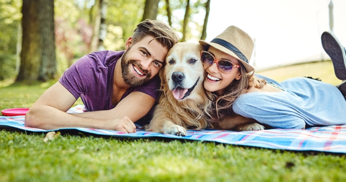 couple outdoors with their dog